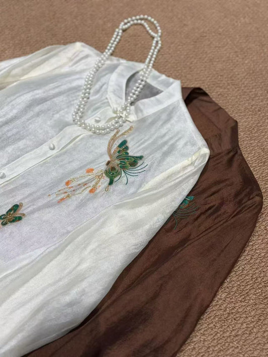 Butterfly beaded blouse styled with pearl necklace and brown trousers