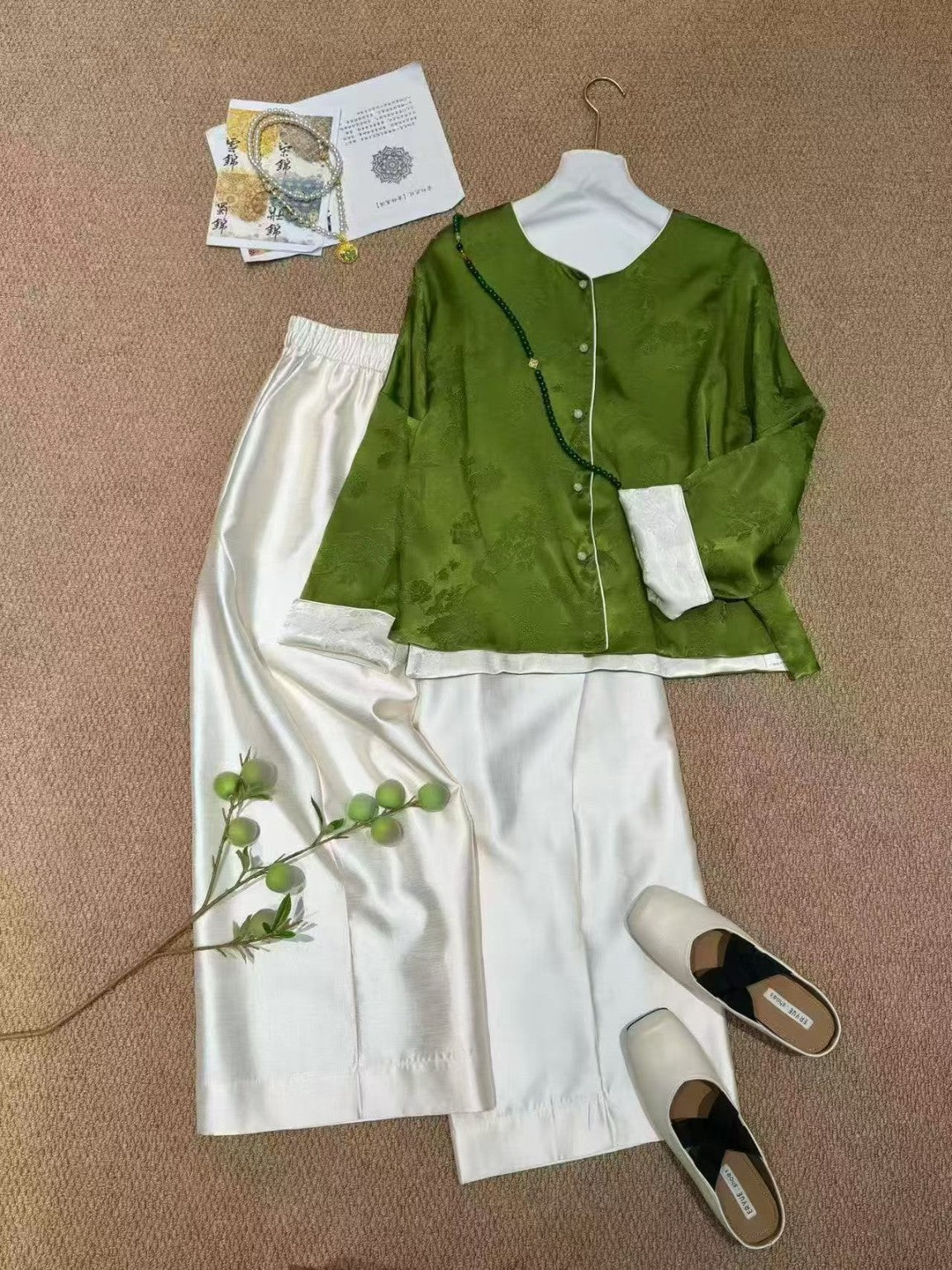 Ivory trousers styled with jade green reversible jacquard jacket